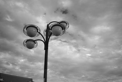Low angle view of street light against cloudy sky