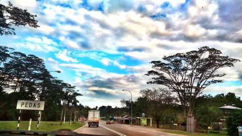 Country road against cloudy sky