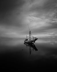 Fishing boat in sea against sky