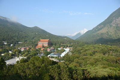 Houses by trees and mountains against sky