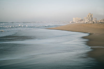 Sea saves reaching beach at praia de silvalde in espinho , portugal , at sunset