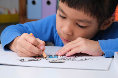 Close-up of boy drawing on table