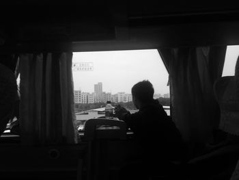 Man looking through window while traveling in train