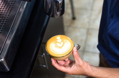 High angle view of man holding coffee cup