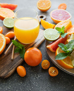 Glass of juice and fresh citrus fruits