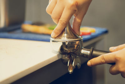 Close-up of person holding cigarette on table