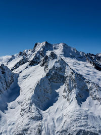 Scenic view of snowcapped mountains against clear blue sky