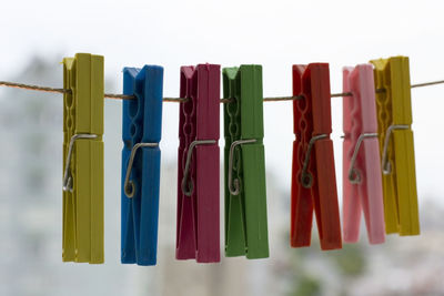 Close-up of multi colored clothespins hanging on rope