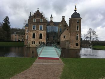 Building by river against sky