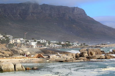 Scenic view of sea by buildings against sky