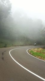 Empty road with trees in background