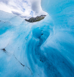 Aerial view of frozen lake against blue sky