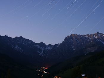 Scenic view of mountains against light trails in sky at night