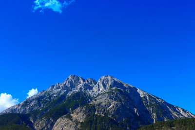 Low angle view of mountain against blue sky