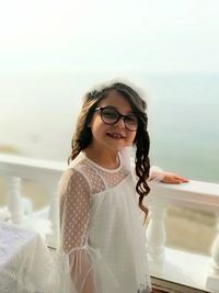 Portrait of smiling girl standing at balcony