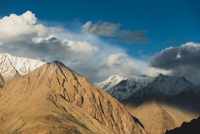 Scenic view of snowcapped mountains against cloudy sky