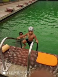 High angle view of couple sitting on swimming pool