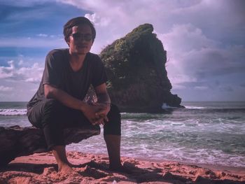 Portrait of man sitting at beach