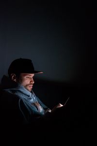 Man using smart phone against sky at night