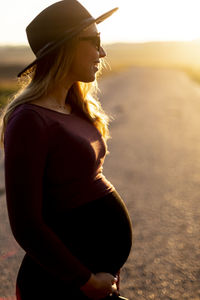 Side view of young woman standing on land