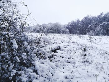 Snow covered landscape against clear sky