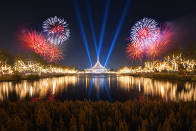 Firework display over river at night