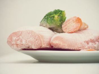 Close-up of bread in plate against white background