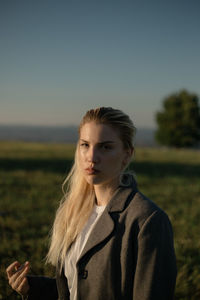 Portrait of woman standing on field against clear sky