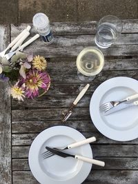 Directly above shot of wineglass and drinking glass by eating utensils on table