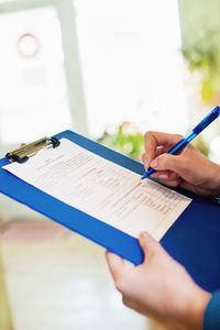 Cropped hands of doctor writing on paper