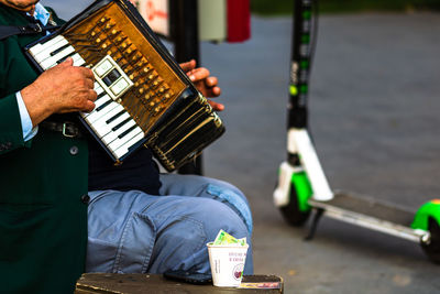 Midsection of man playing guitar at music concert