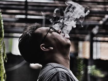 Portrait of young man smoking outdoors