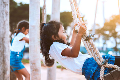 Sisters swinging at playground