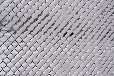 Low angle view of chainlink fence against sky