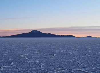 Scenic view of snowcapped mountains against sky during sunset