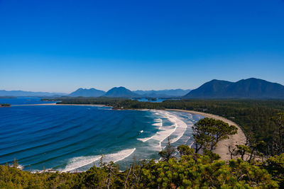 View over cox bay beach on sunny day with surfers