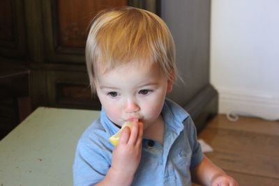Baby boy eating lemon at home