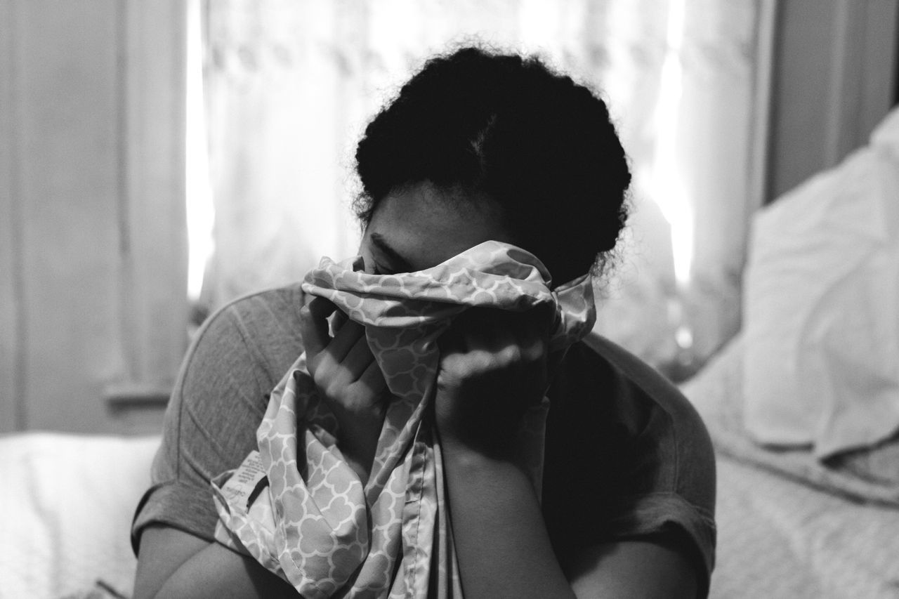 CLOSE-UP OF YOUNG WOMAN LYING IN BED