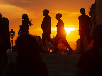 Silhouette people at beach during sunset
