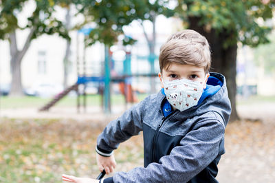 Portrait of cute boy sitting outdoors