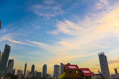 Aerial view of city buildings against sky during sunset