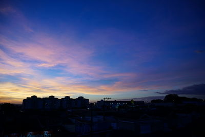 High angle view of silhouette buildings against sky at sunset