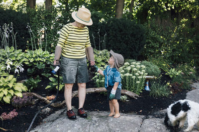 Grandmother with grandson standing in garden