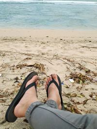 Low section of person relaxing on beach