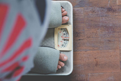Low section of woman standing on weight scale