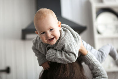 Mom and baby spend time together, mom sits at home with the baby. real interior and light toning