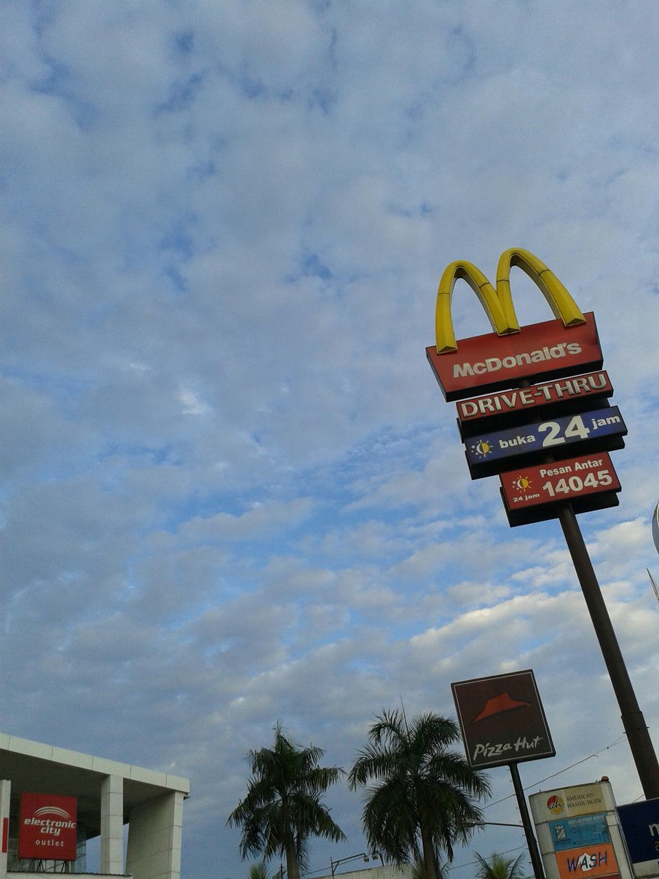 text, western script, communication, low angle view, sky, information sign, sign, guidance, road sign, information, cloud - sky, capital letter, non-western script, tree, cloudy, directional sign, warning sign, arrow symbol, cloud, signboard