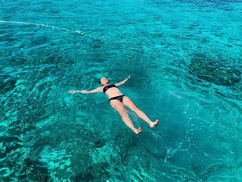 High angle view of woman swimming in sea