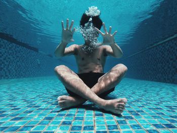 Full length of shirtless boy swimming in pool