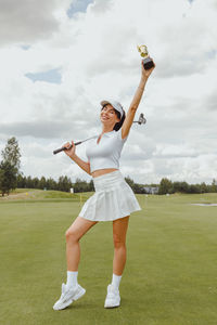 Full length of young woman doing yoga on field